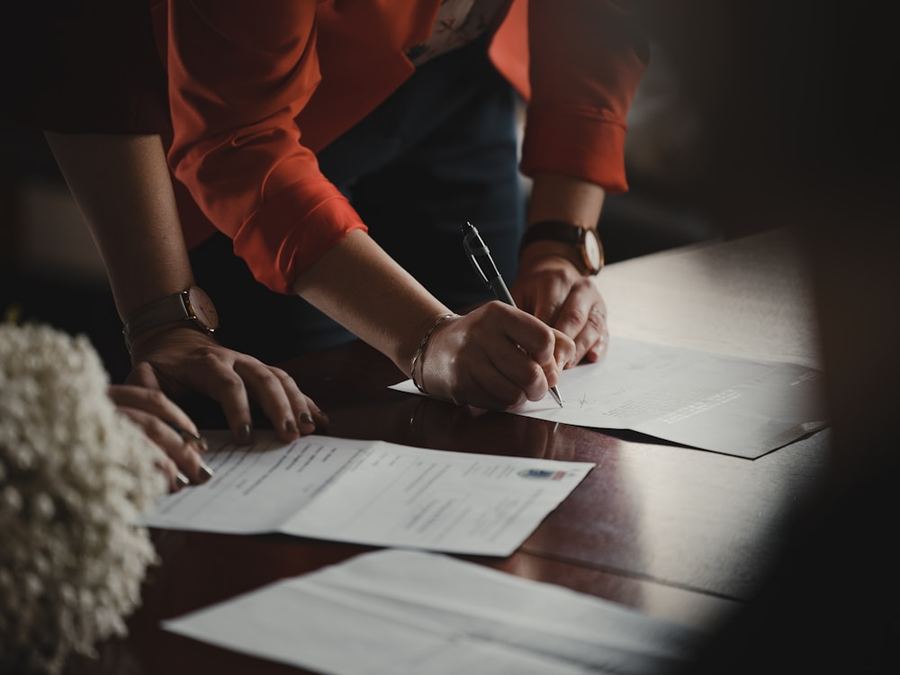 A person reviewing and signing documents at a desk