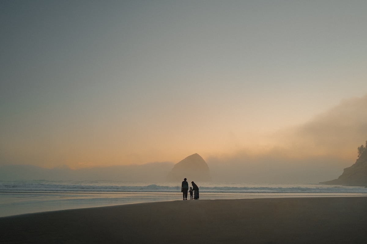 A family standing together on a beach at sunset